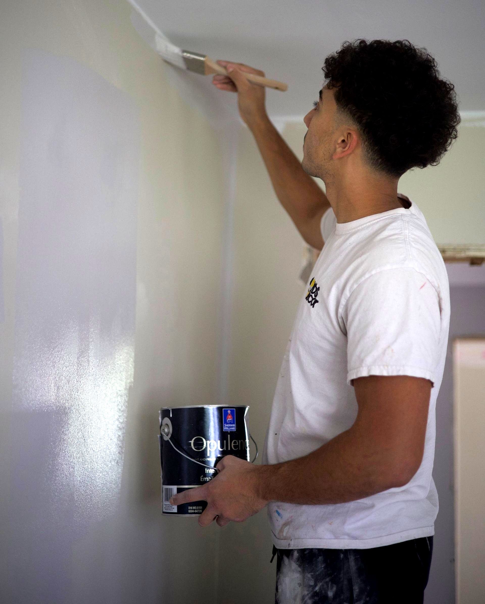 Painter rolling a fresh coat of paint on the wall